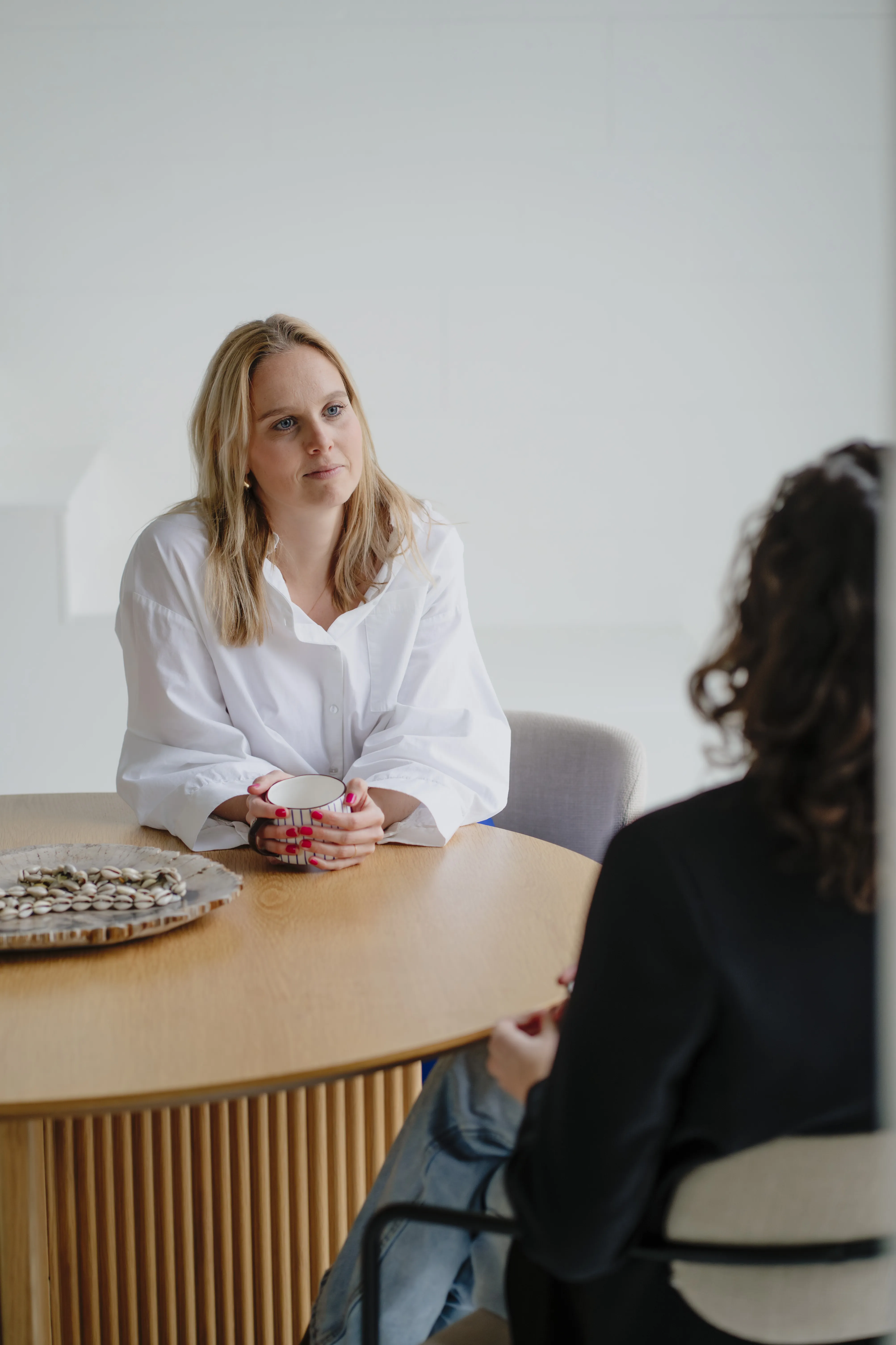 Imke in gesprek aan tafel met een opdrachtgever